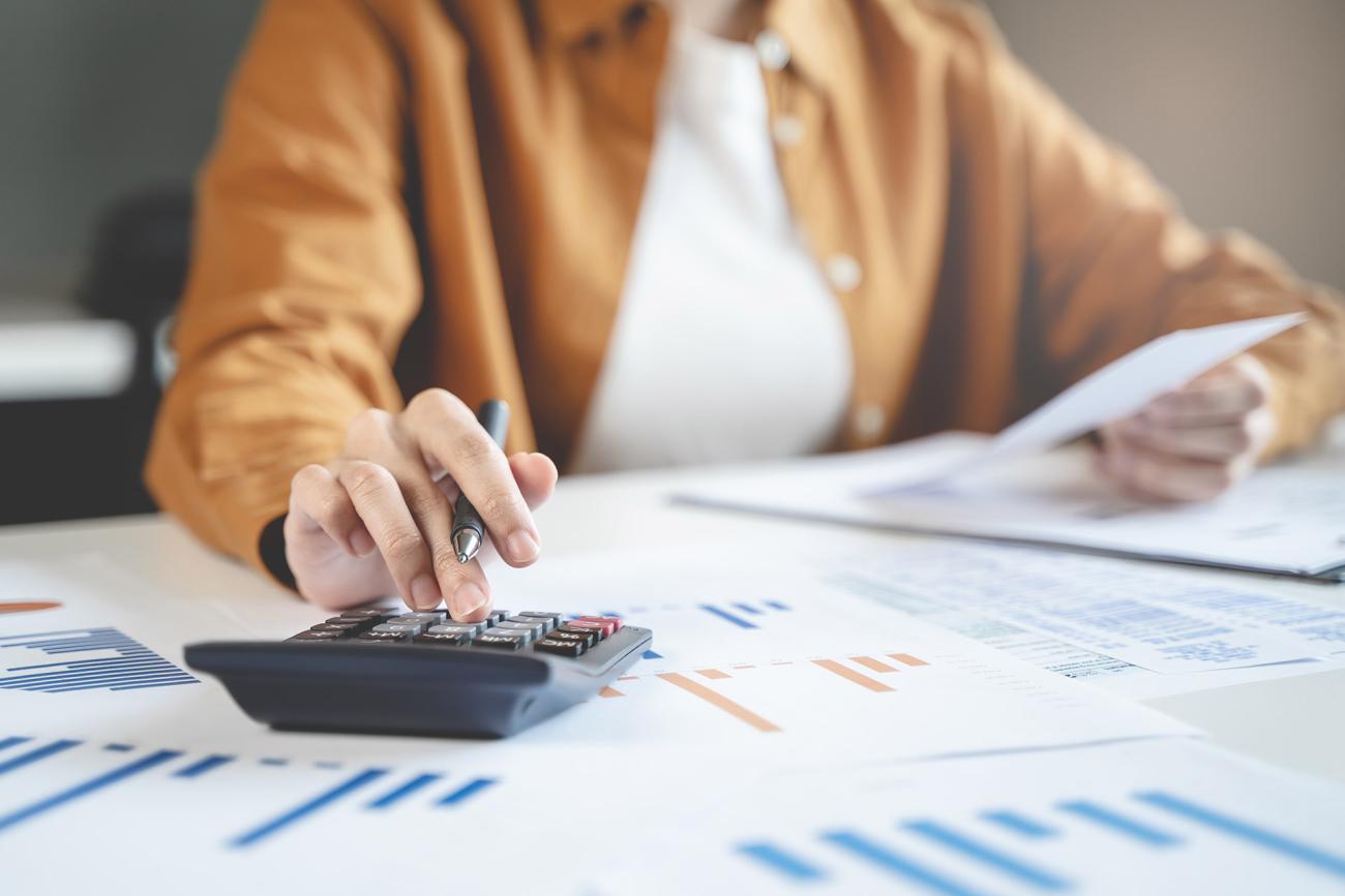Woman using calculator while managing her finances